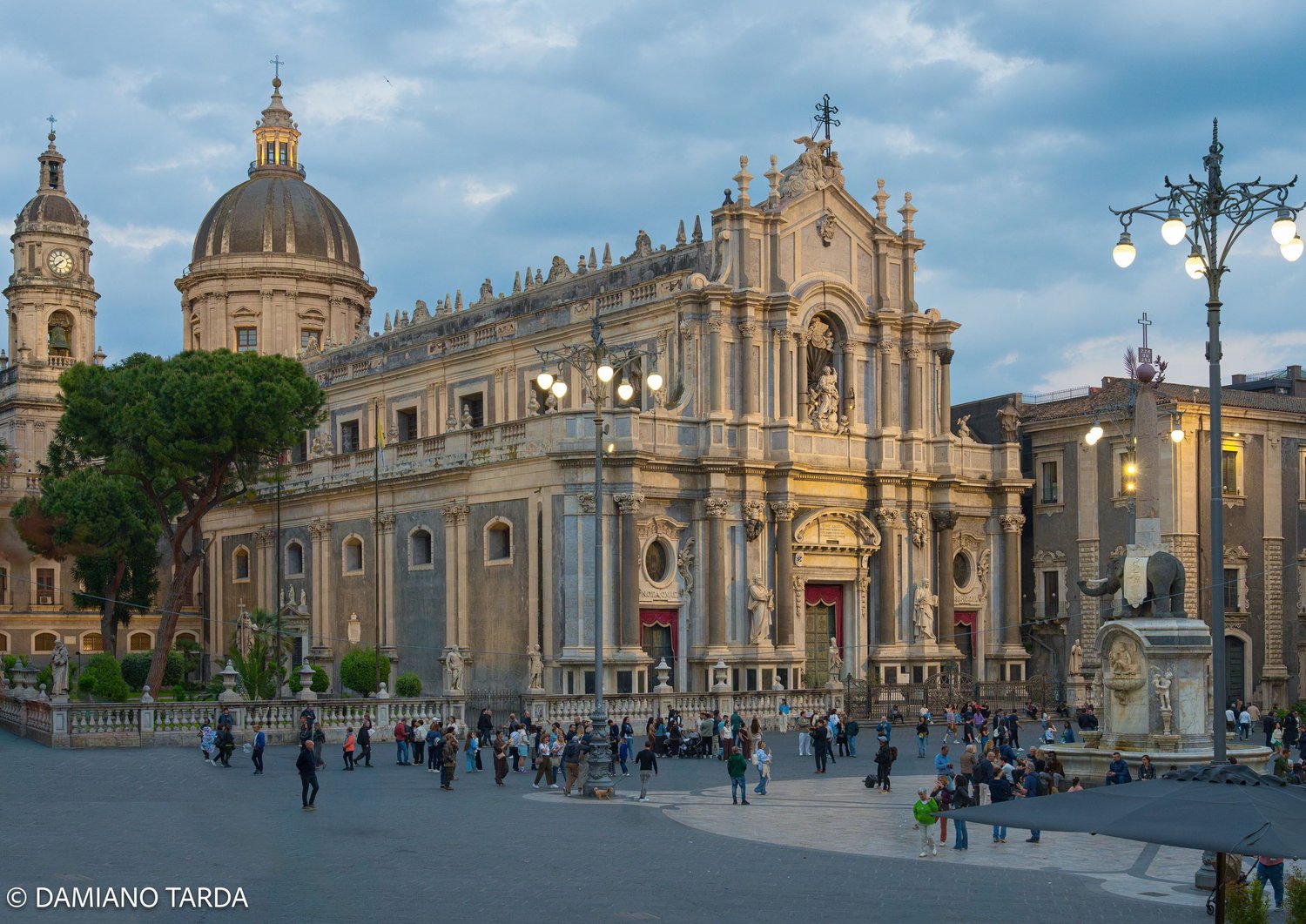 Catania, Piazza Duomo at dusk with the Cathedral of Saint Agatha and the dome of the Badia di Sant'Agata.
