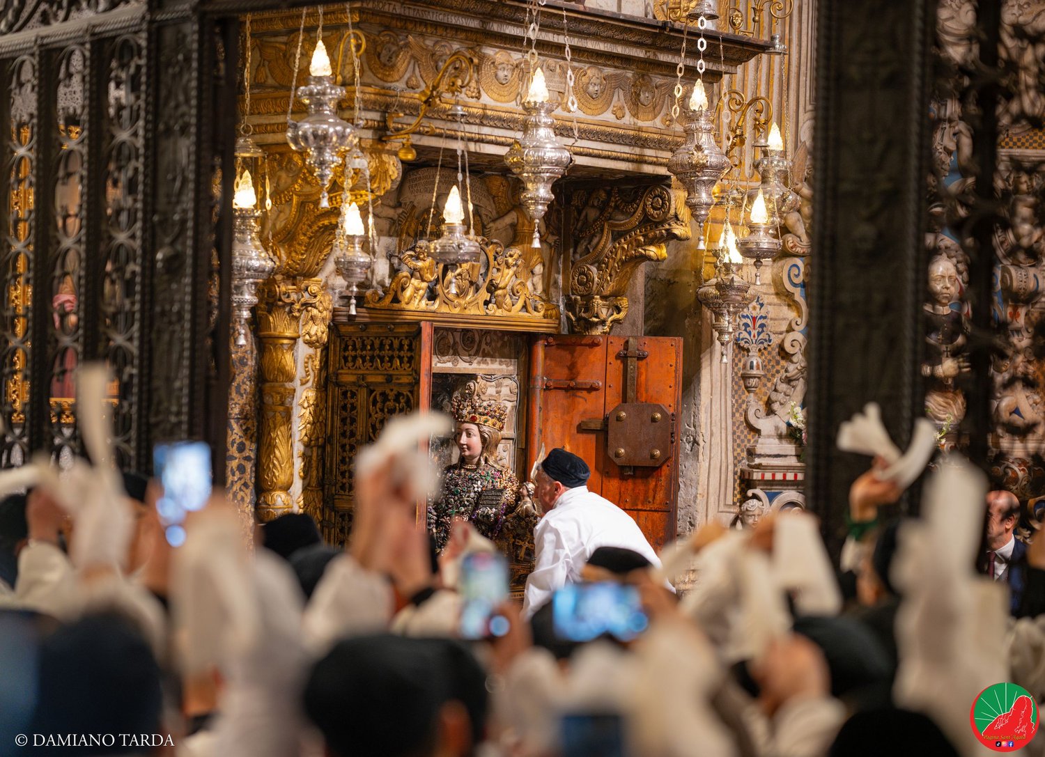 Devotees in white robes wave handkerchiefs in Catania Cathedral as Saint Agatha comes out.