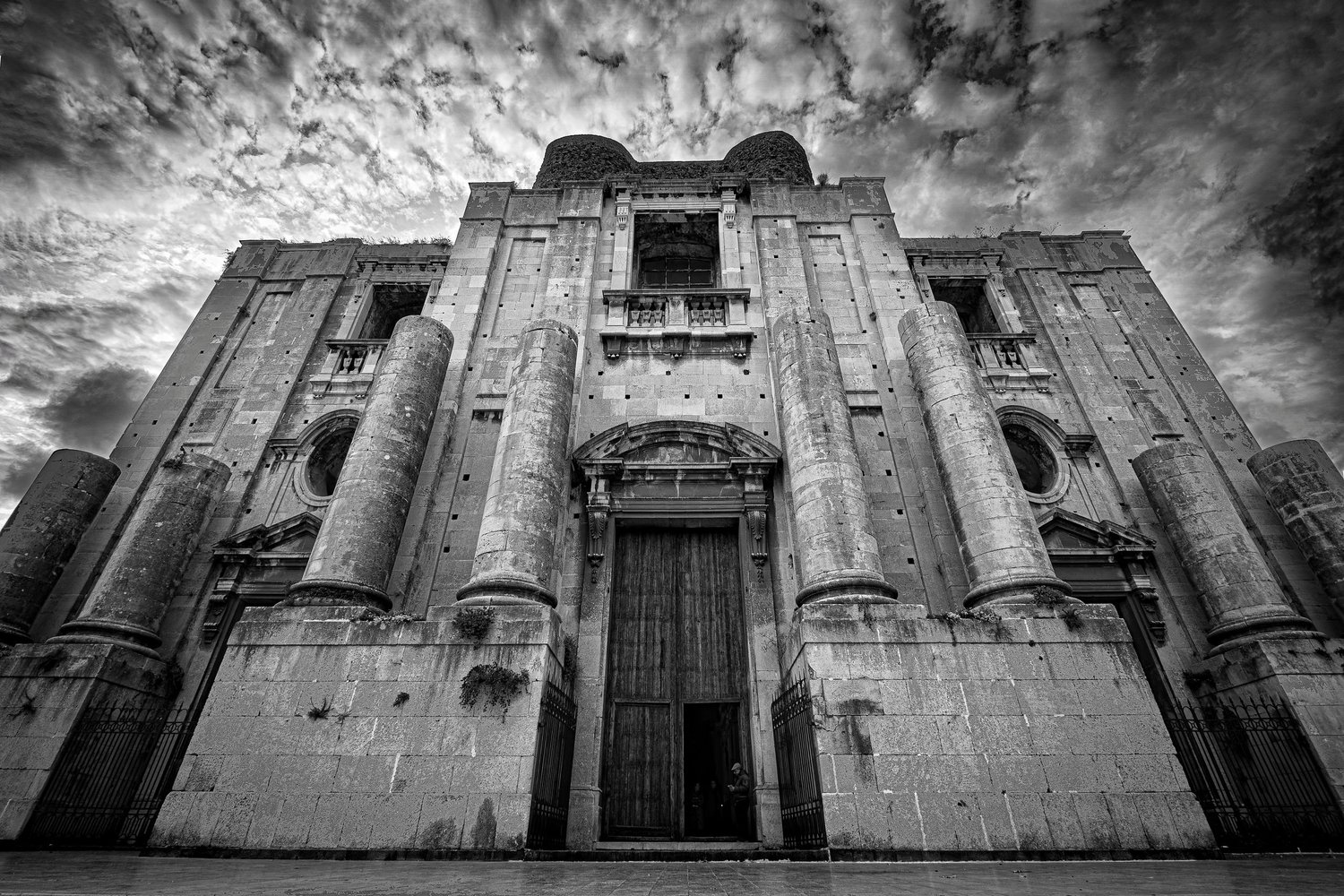 Façade of the Church of San Nicolò l'Arena in black and white, dramatic architectural photography, Catania.