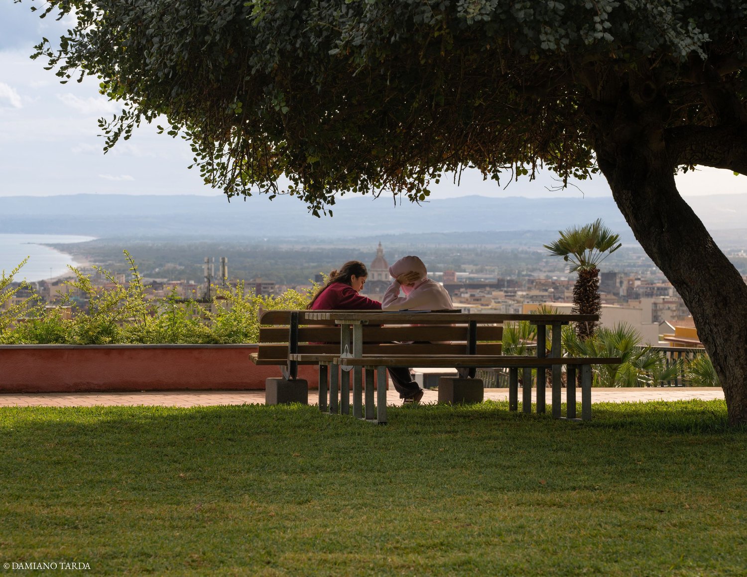 Panoramic photograph of Catania, two young people talking as they look at the skyline