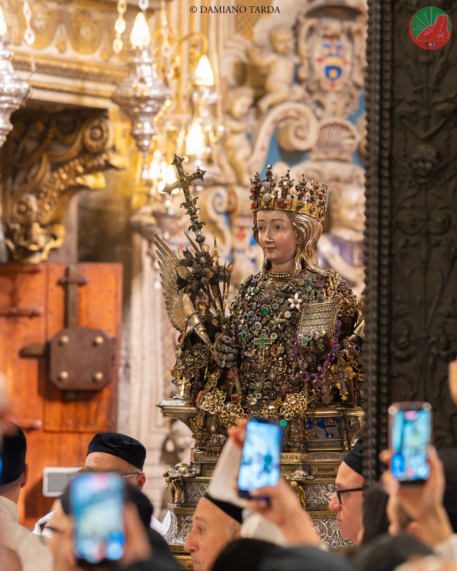 The bust of Saint Agatha in Catania Cathedral, among gilded decorations and the faithful.
