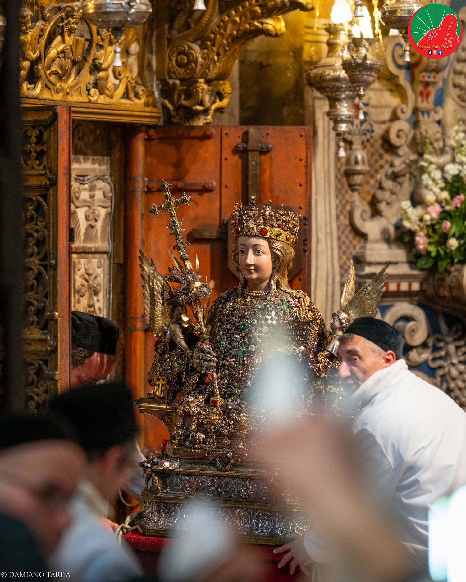 The reliquary bust of Saint Agatha with her jewels in Catania Cathedral, among the devotees.