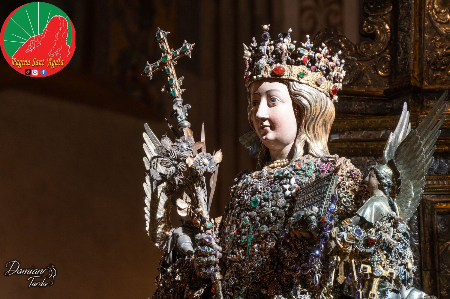 The reliquary bust of Saint Agatha on a dark background, with the crown and the jewelled cross.