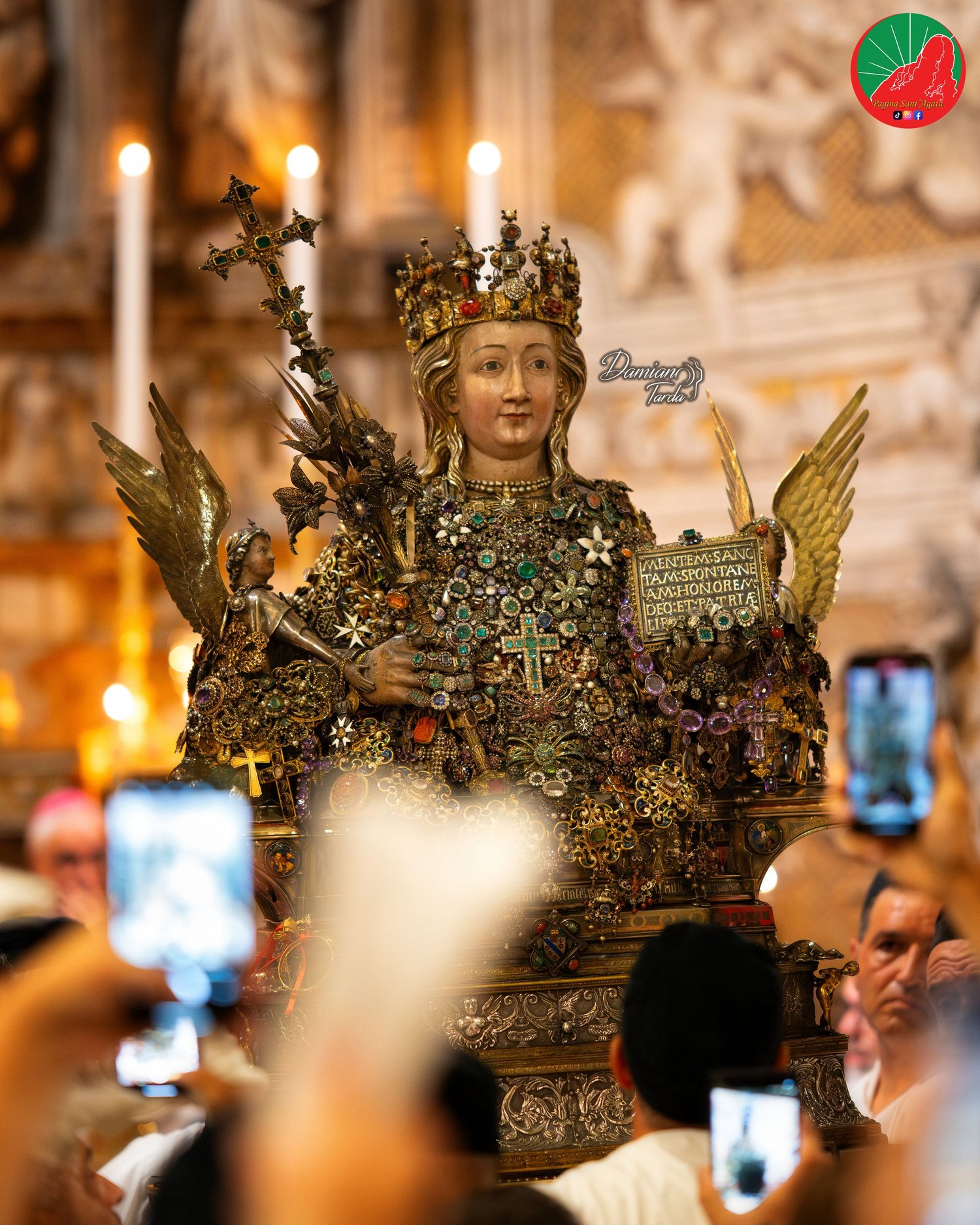 The reliquary bust of Saint Agatha among the raised smartphones of devotees in the Cathedral.