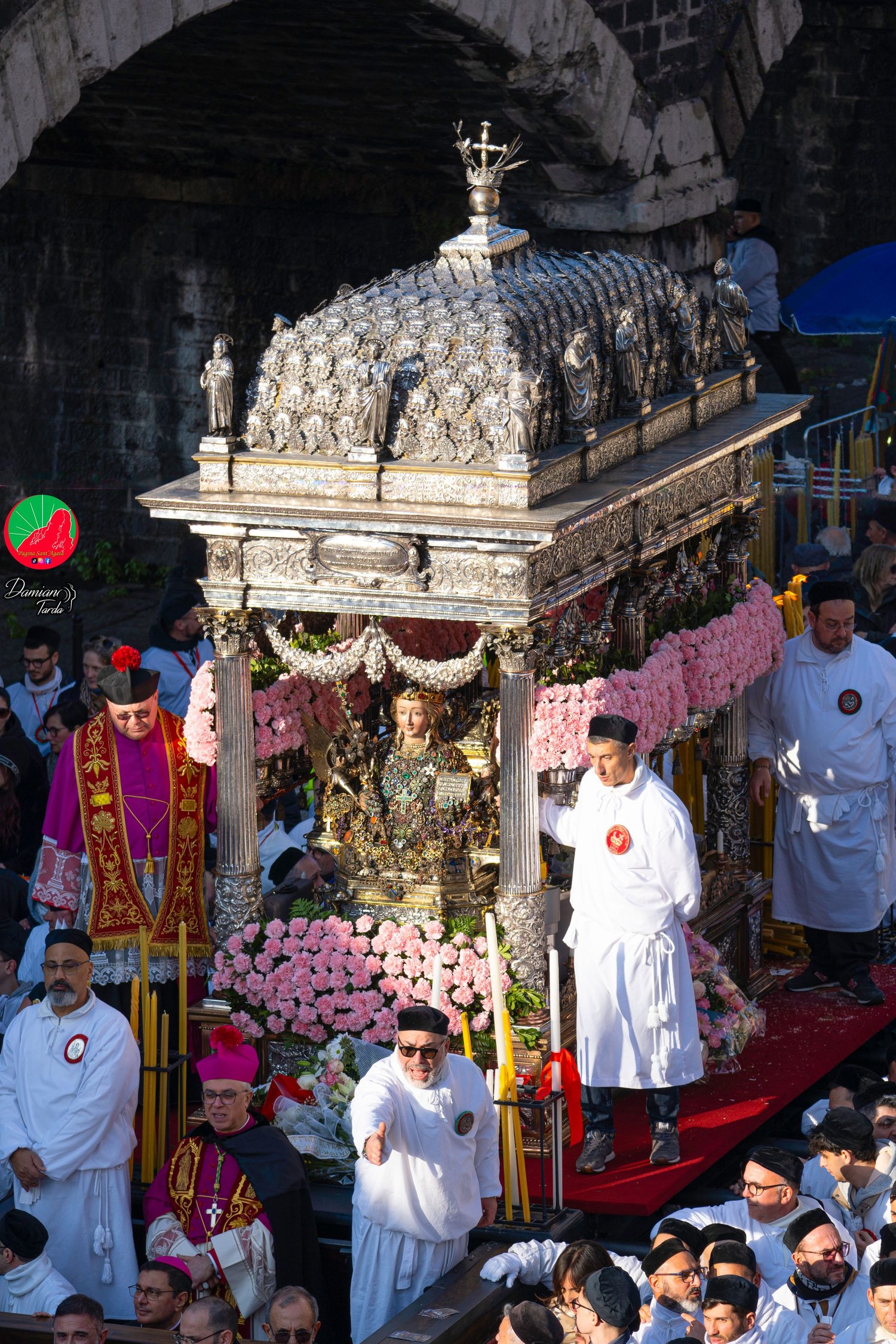 Saint Agatha's silver fercolo, adorned with carnations, surrounded by devotees.