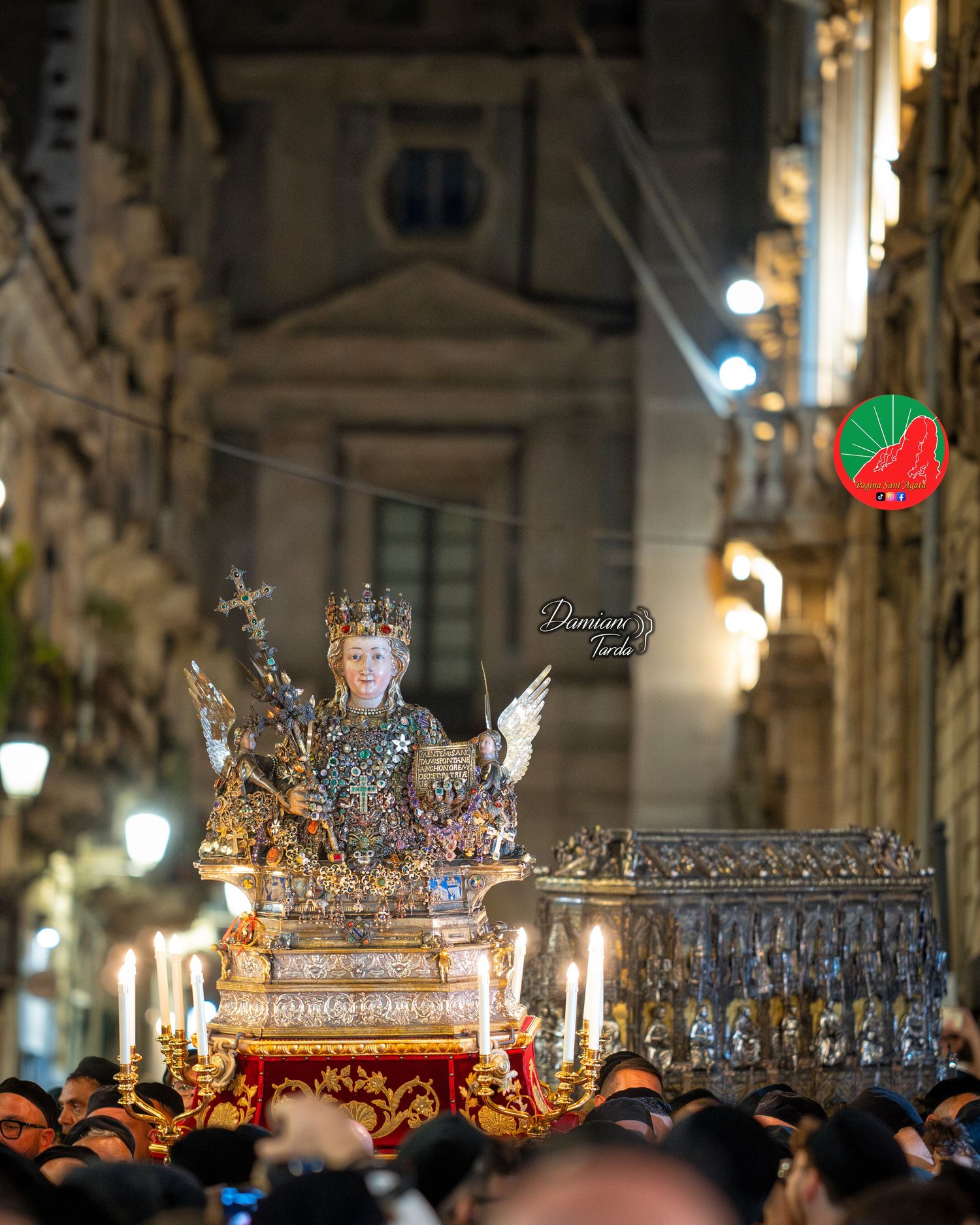 Saint Agatha's fercolo at night among the devotees' candles in the streets of Catania.