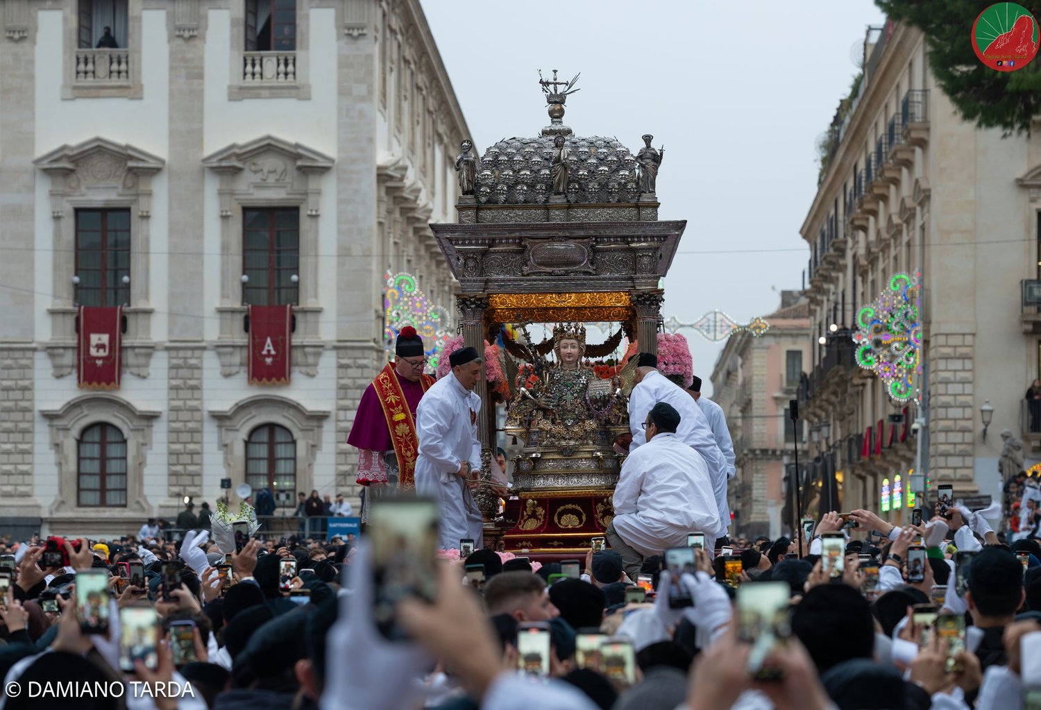 Saint Agatha's fercolo in procession among the crowd of devotees in the streets of Catania.