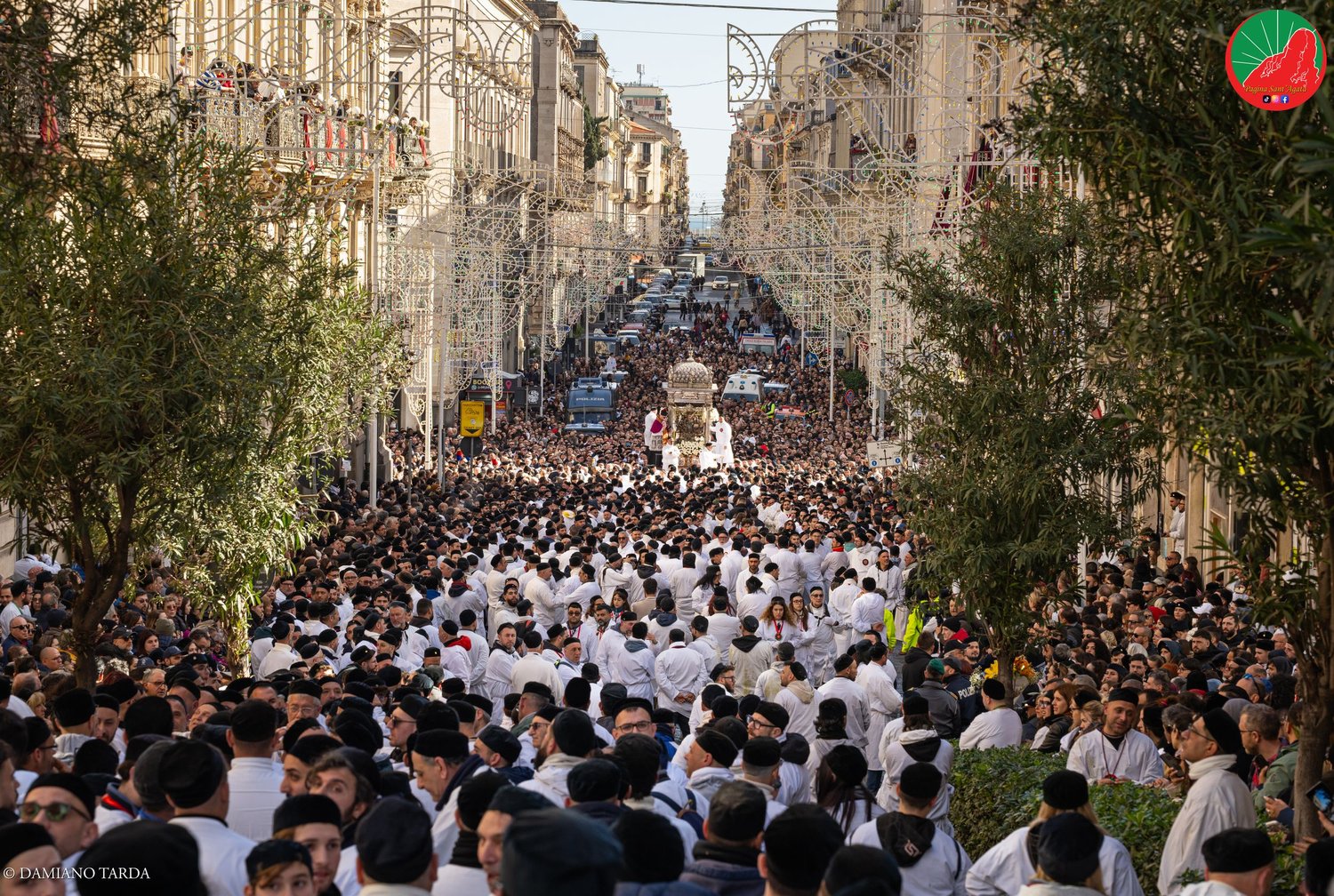 The procession of Saint Agatha climbs Via Etnea among thousands of devotees in white robes.