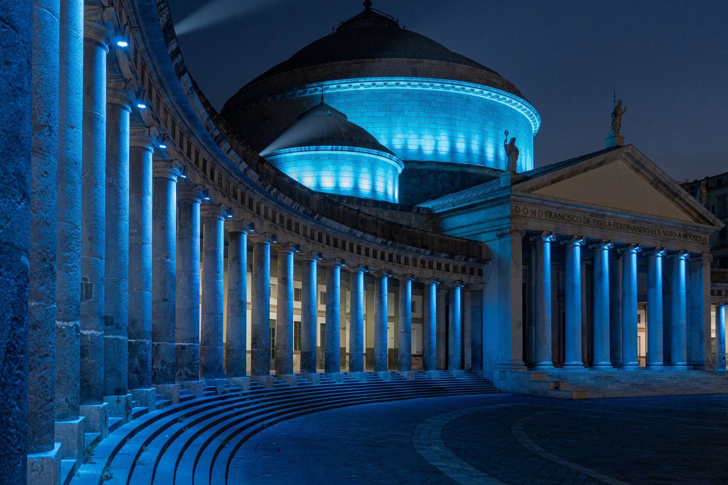 Piazza del Plebiscito a Napoli di notte, colonne e luci in una fotografia urbana astratta